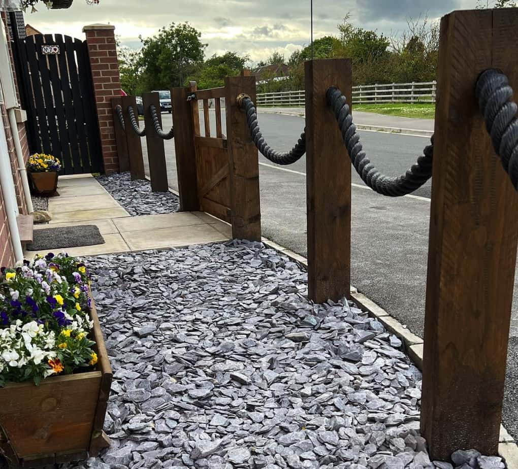 A house with decking posts and black decking rope in garden.